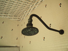 シャワーヘッドがあるタイル貼りのお風呂